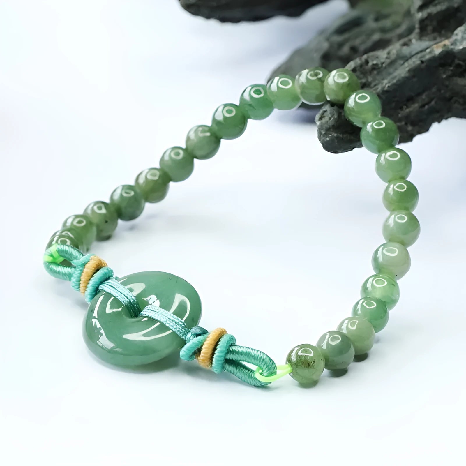 Emerald green jade bracelet with safety buckle closure and star charm on wrist