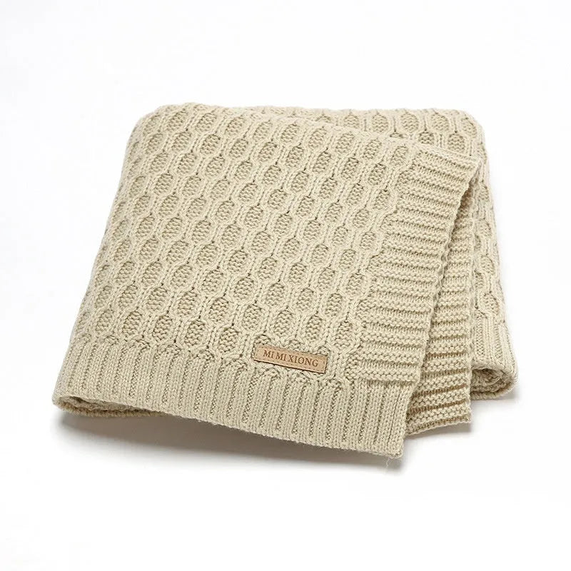 Solid colour baby blanket with textured three-dimensional lines, shown in beige khaki.