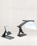 Black folding mobile phone screen magnifier with detachable holder next to an iPhone.