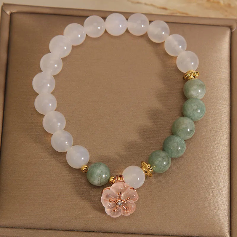 White agate jade flower bracelet with pink accent stones on wrist