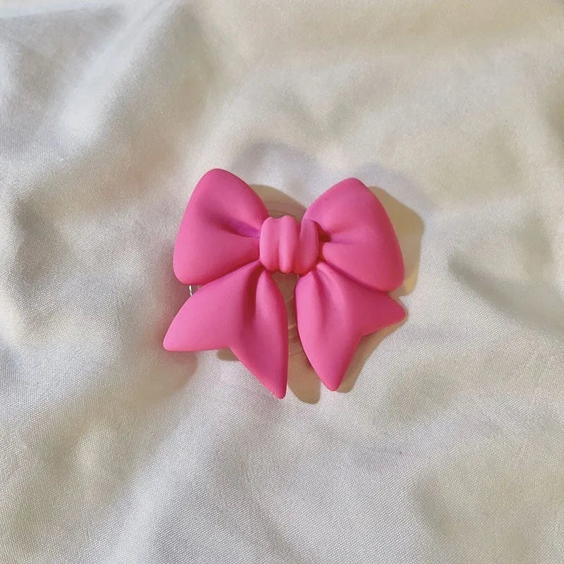 Bow bracket plastic mobile phone stand for lazy binge-watching, available in pink, purple, rose red, yellow, and blue.