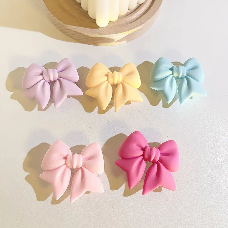 Bow bracket plastic mobile phone stand for lazy binge-watching, available in pink, purple, rose red, yellow, and blue.