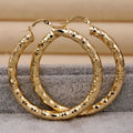 Pair of gold-coloured retro classic alloy earrings for women on a neutral background