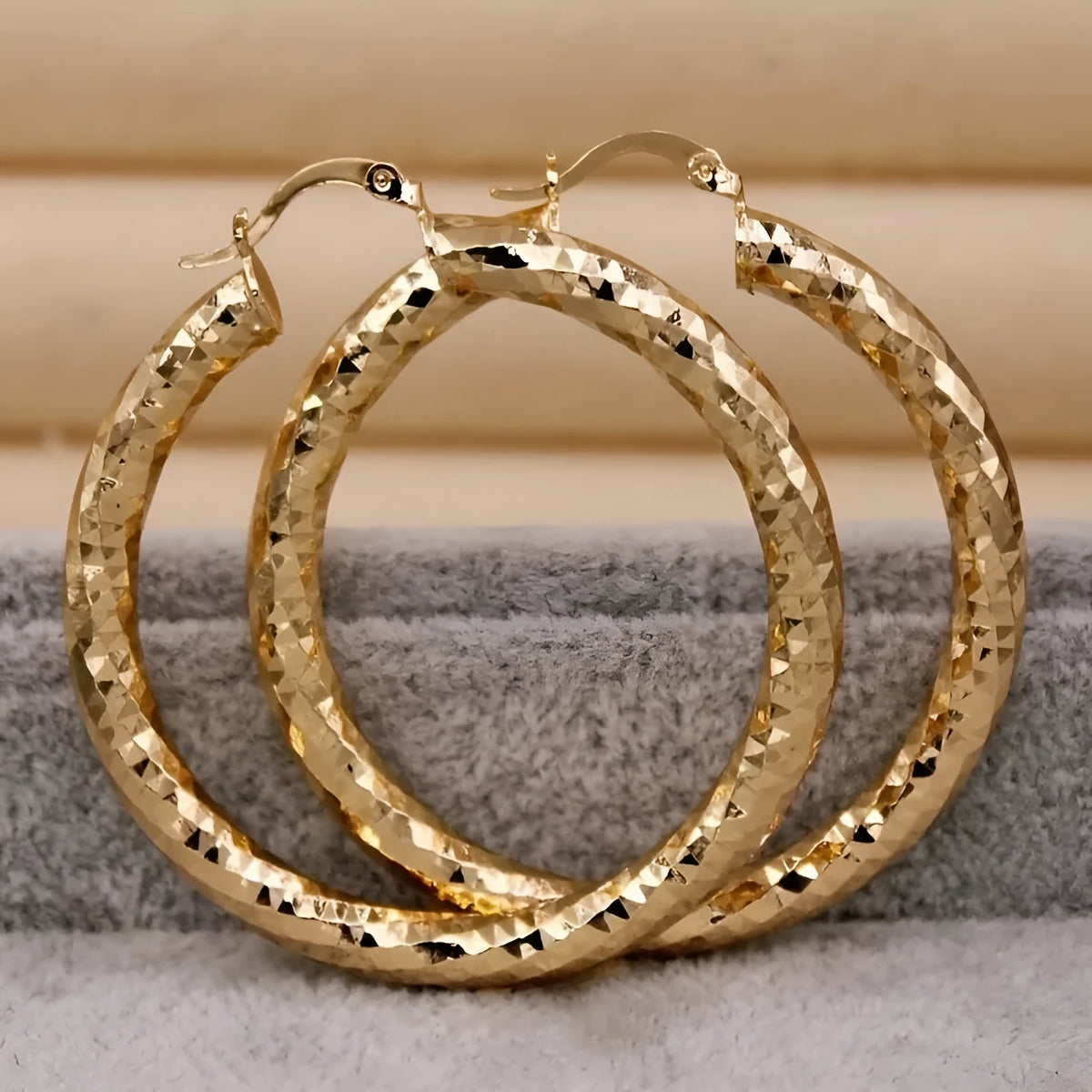 Pair of gold-coloured retro classic alloy earrings for women on a neutral background