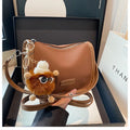 High-textured PU messenger bag with leopard print, horizontal square shape, and decorative pendant