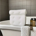 White bathtub pillow with mesh fabric and seven large suction cups on the back.