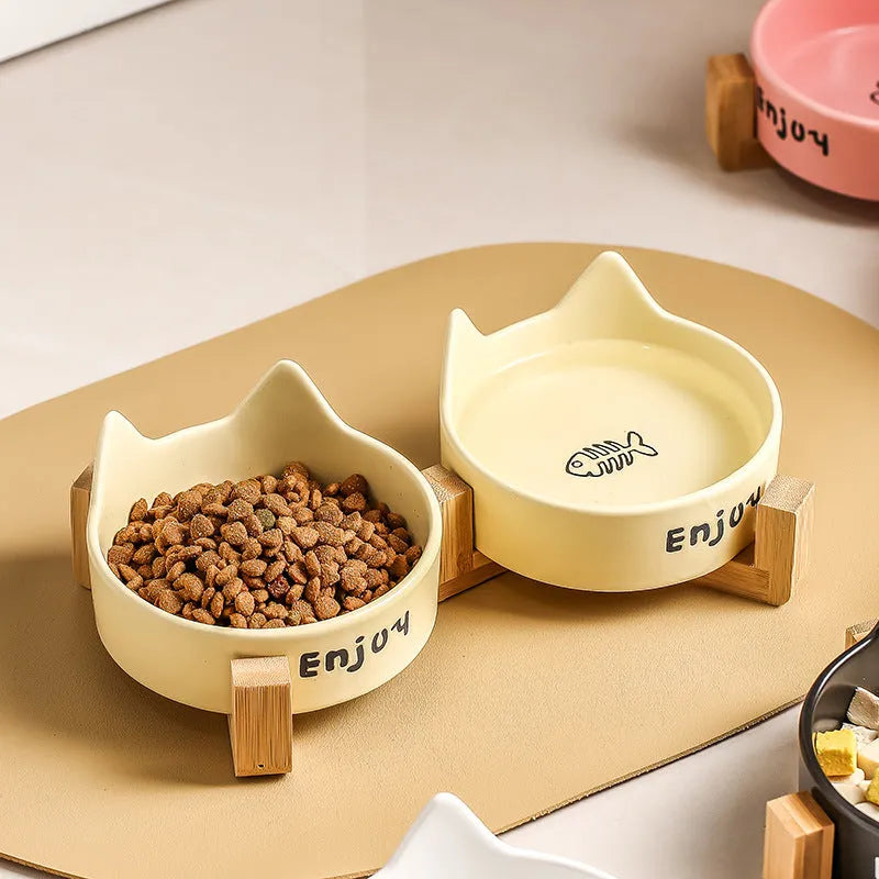 Porcelain cat bowl with cat ear and paw design on a wooden feeding frame, in pink colour.