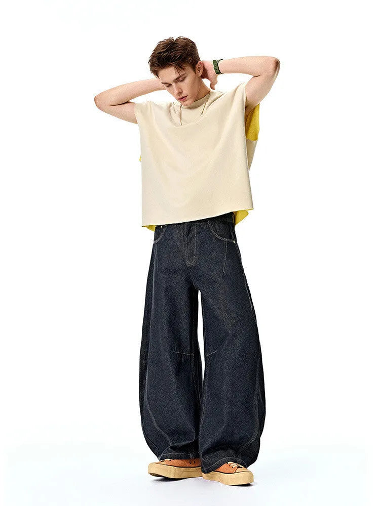 Men's wide leg denim trousers in original cow colour showing relaxed fit and mid waist design.