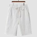 Pair of beige men's casual linen shorts with a loose fit and cropped length on a plain background.