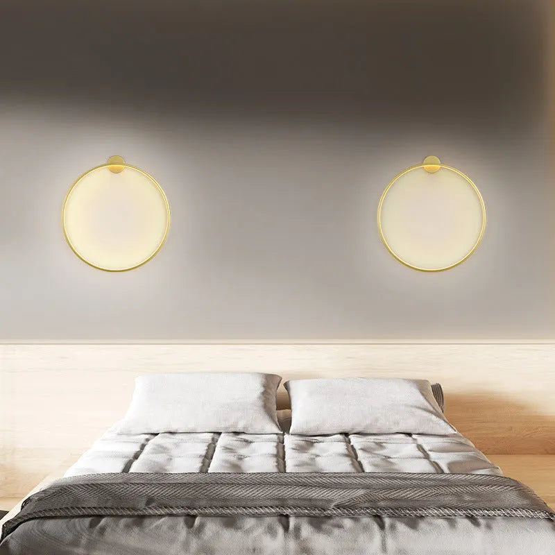 Minimalist black ring wall lamp with acrylic shade mounted on a bedroom wall