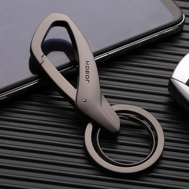 Black zinc alloy rectangular key chain with a carabiner clip and double ring, shown next to a set of keys for scale.