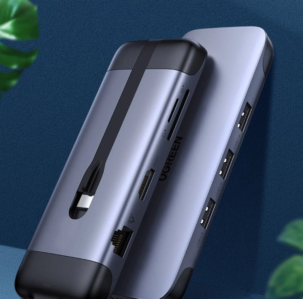 USB-C to multi-port docking station adapter with short cable shown next to a laptop, displaying HDMI, USB, and charging ports.