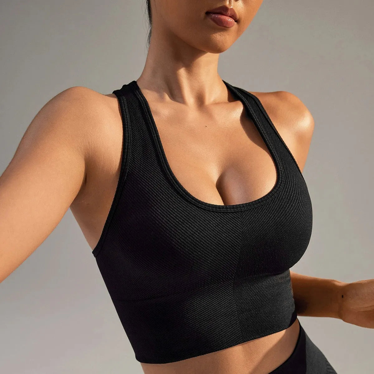 Black women's cross-back sports bra with fixed double straps and moulded cups.