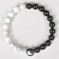 White turquoise and natural obsidian 8mm bead bracelet on a flat surface