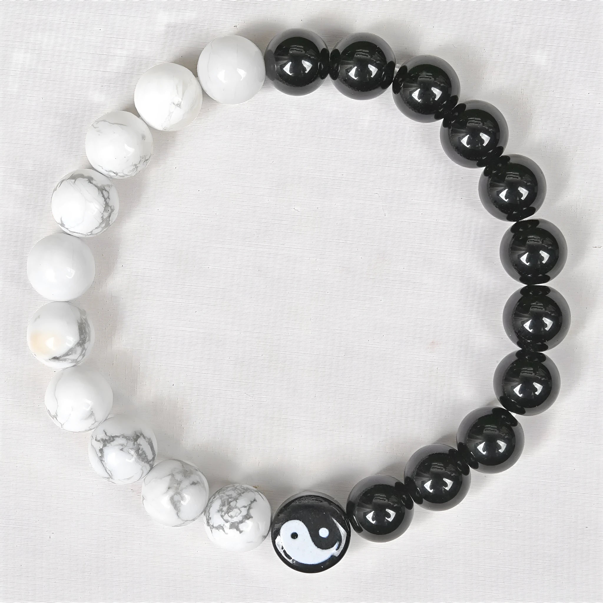 White turquoise and natural obsidian 8mm bead bracelet on a flat surface