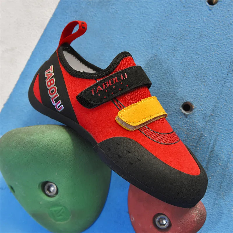 Beginner rock climbing shoes with Velcro strap in black and red colourway.