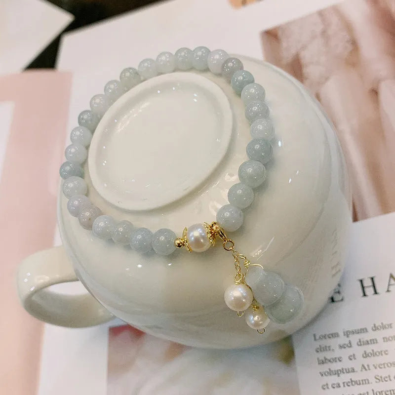 Chinese style women's jade bracelet with traditional gourd design featuring emerald jade insets and pearl elements