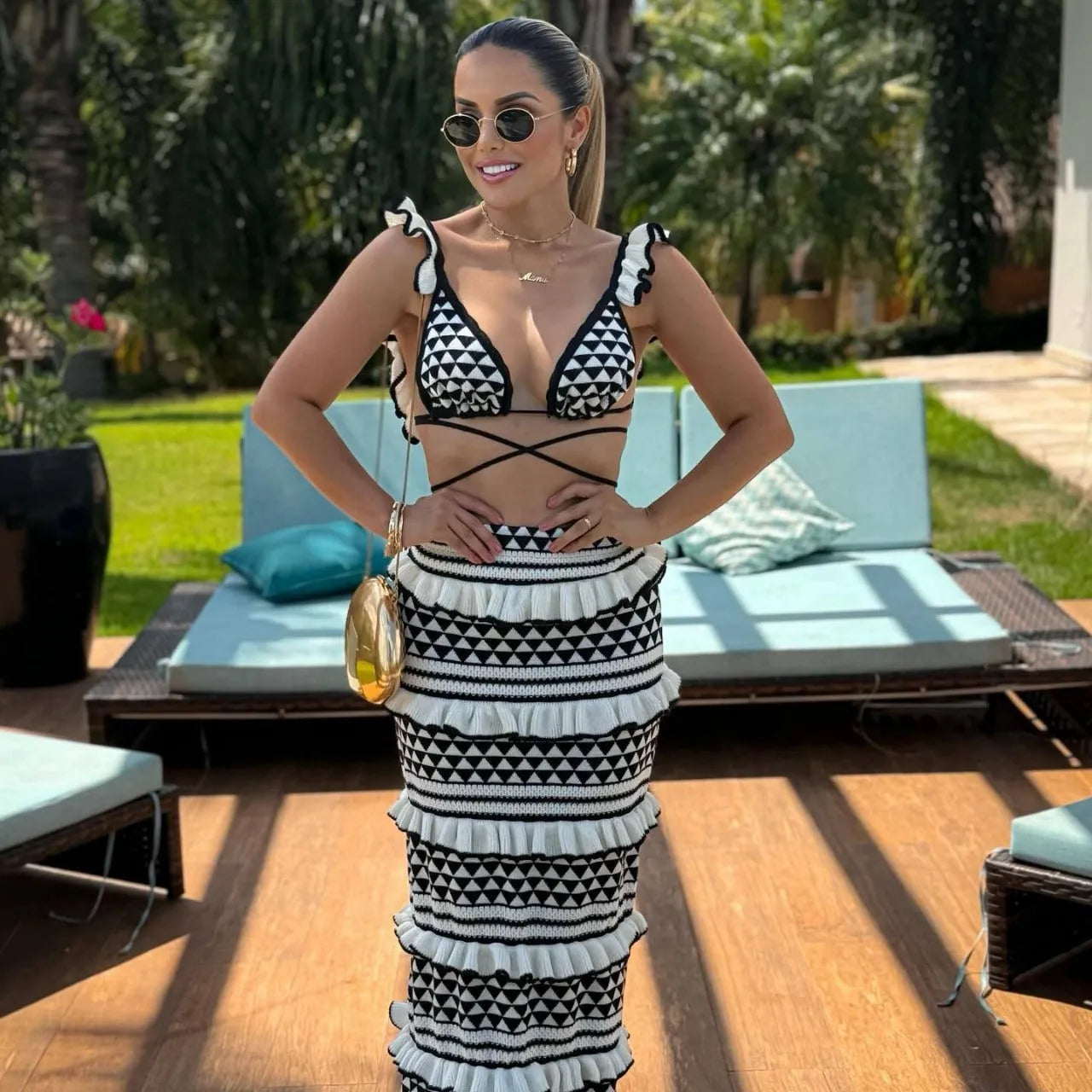 Black and white striped two-piece swimsuit set with ruffled bikini top and long knitted skirt.