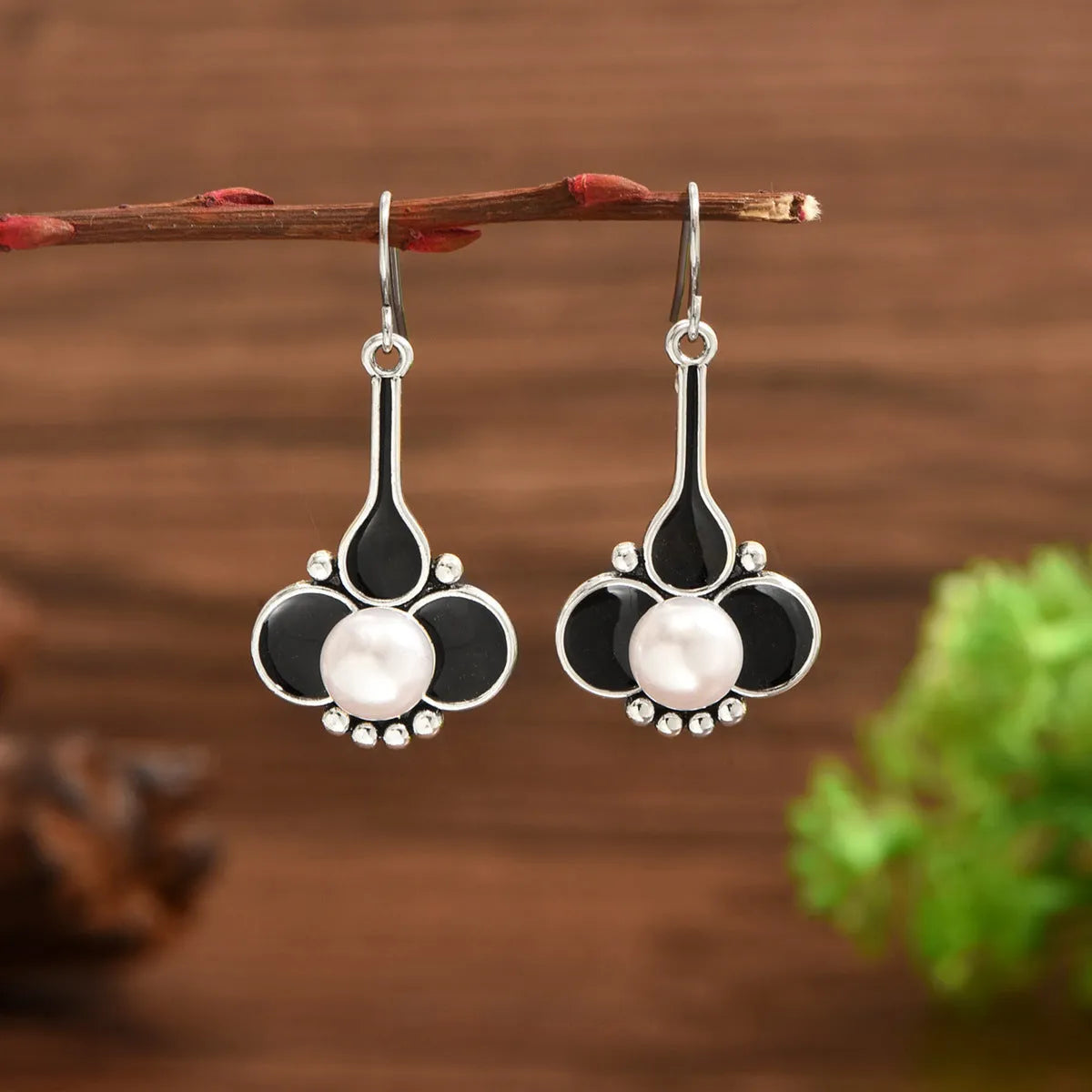 A pair of silver retro fashion earrings for women with a creative design and alloy construction.