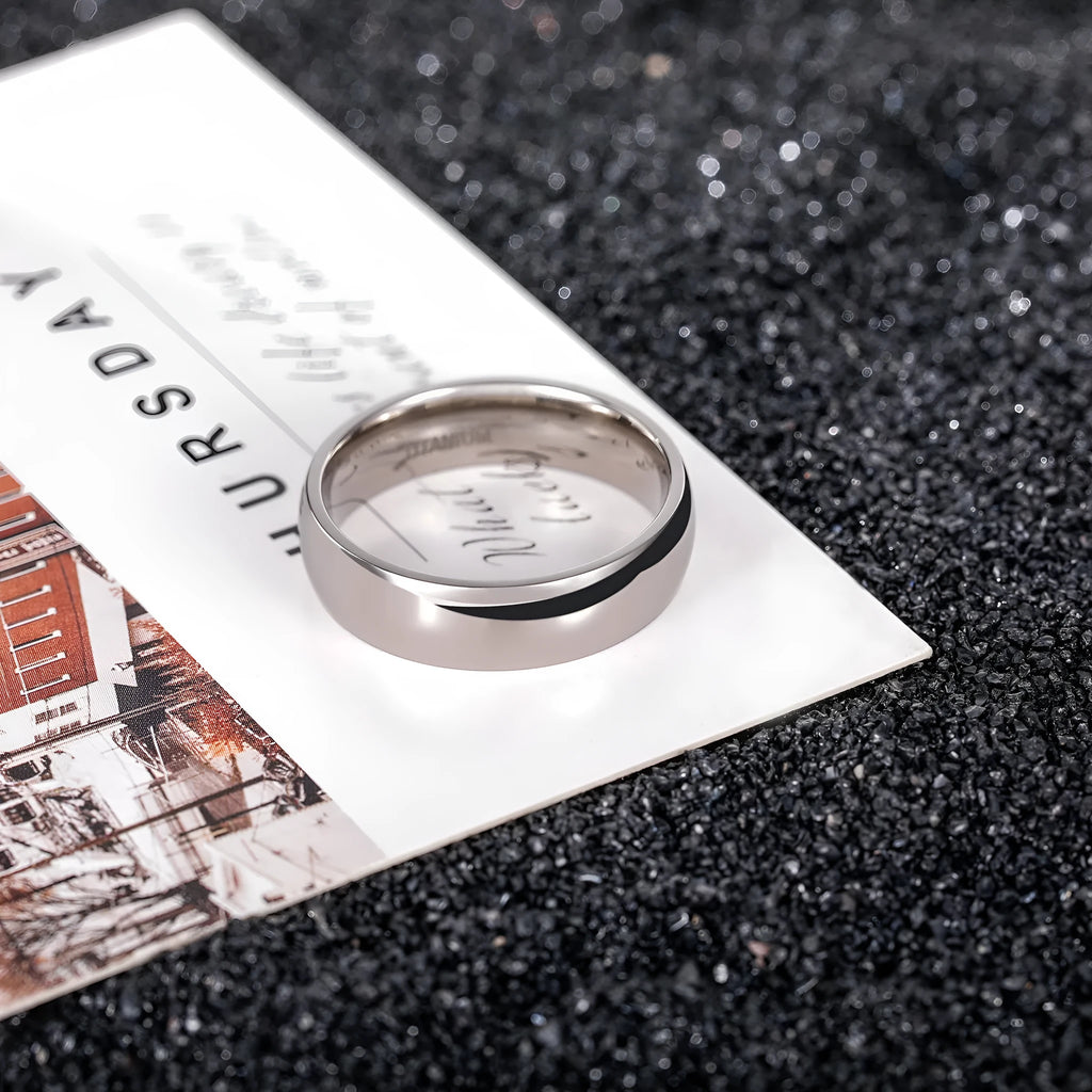 Polished silver titanium ring showing different width options on a finger.