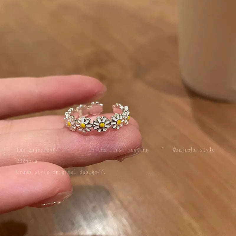 Women's copper opening ring with floral daisy charm and pearl accents on finger