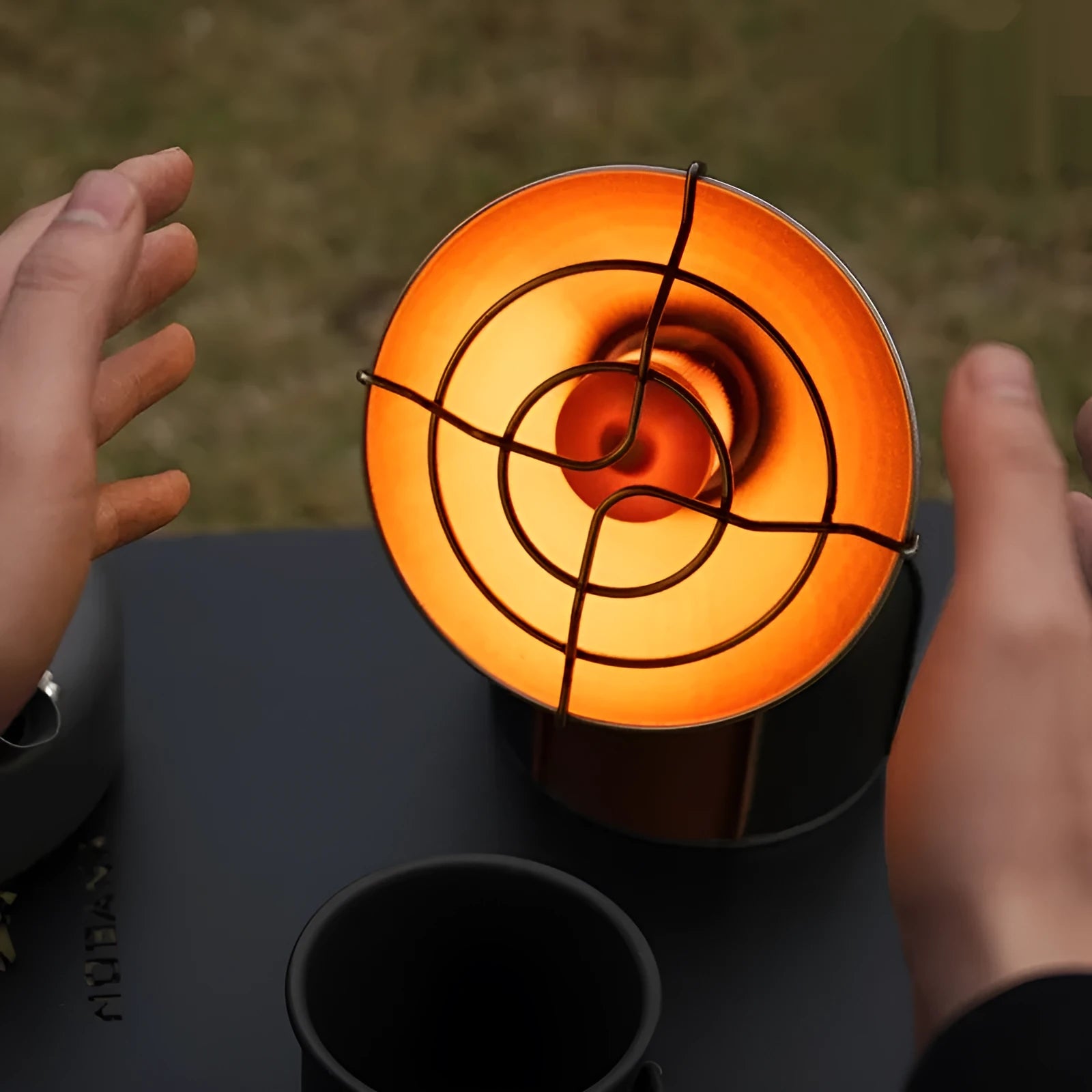 Black and orange portable camping heating stove with automatic ignition.