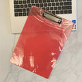 Clear plastic A4 plate holder with metal clip showing document inside, available in blue, green, red and white colours
