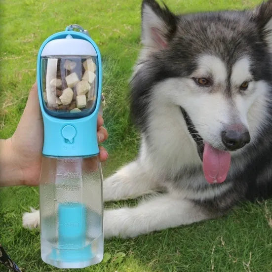 Turquoise portable 3-in-1 dog water bottle with food feeder and built-in poop bag dispenser on a walk