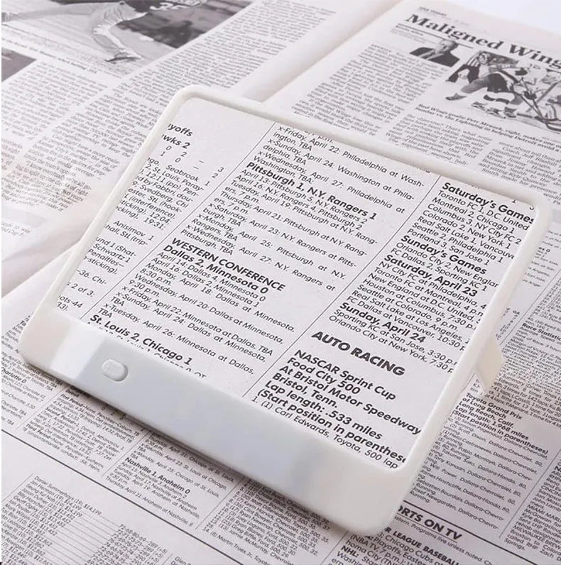 A black magnifying glass with a built-in LED light, showing 3x magnification and dimensions of 180mm by 140mm.