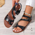 Women's flat sandals with a Velcro strap, round toe, and rubber sole in black, brown, and colourful options.