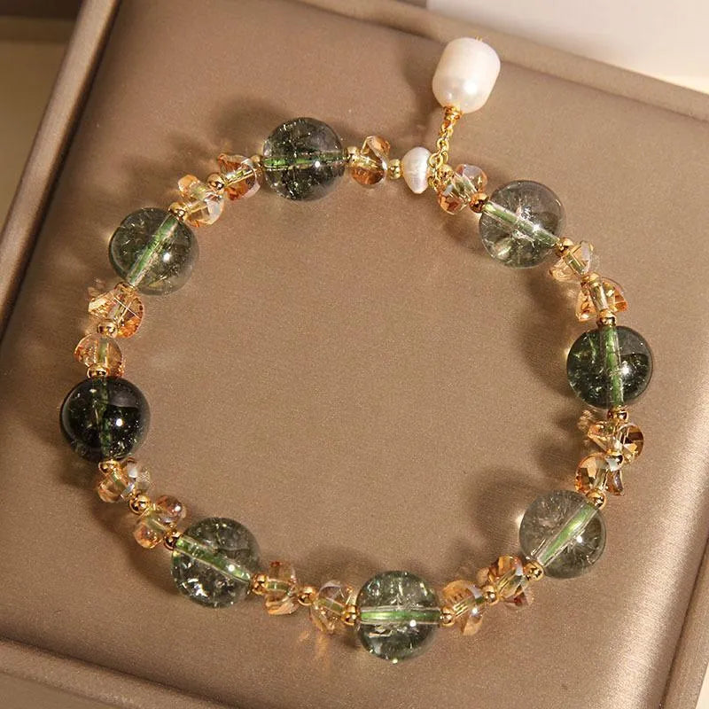 Adjustable green phantom quartz and champagne crystal bead bracelet on a string cord.