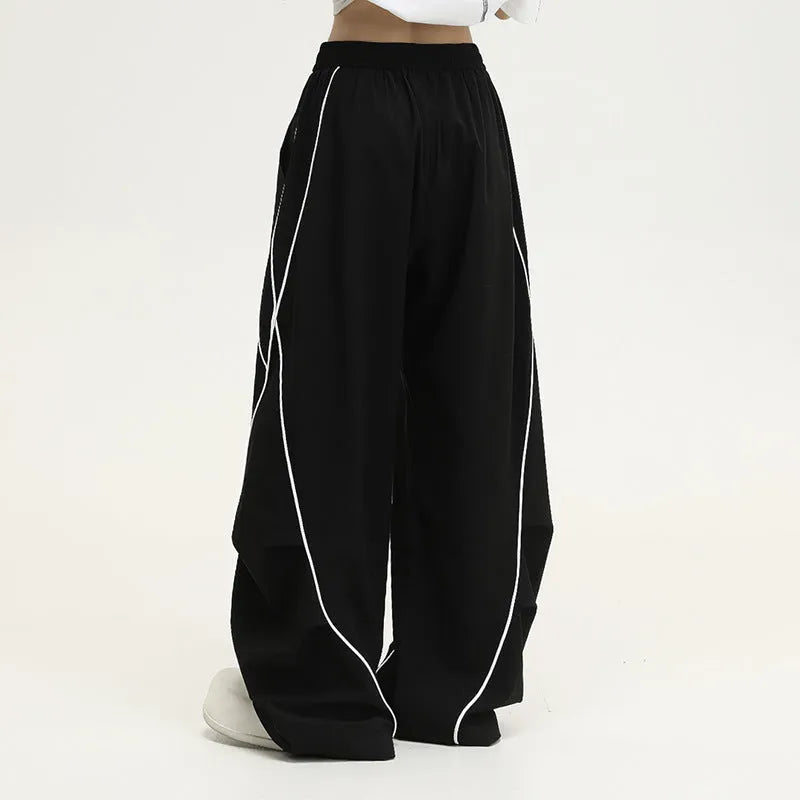 Black striped pleated hip-hop wide-leg sports pants on a hanger.