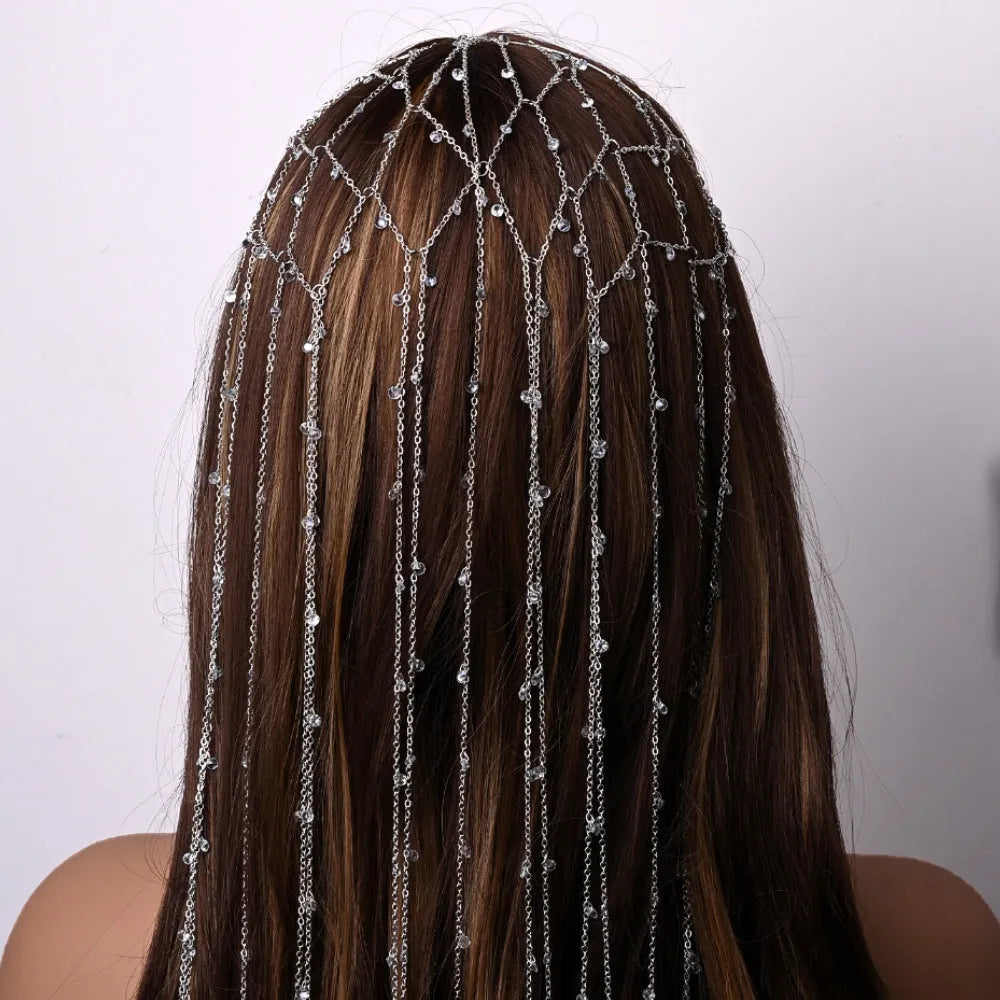 Close-up of a gold rhinestone mesh headband for women with a dangling tassel decoration.