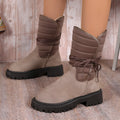 A pair of women's chunky heel snow boots in suede with a lace-up front and fleece lining, shown in black.