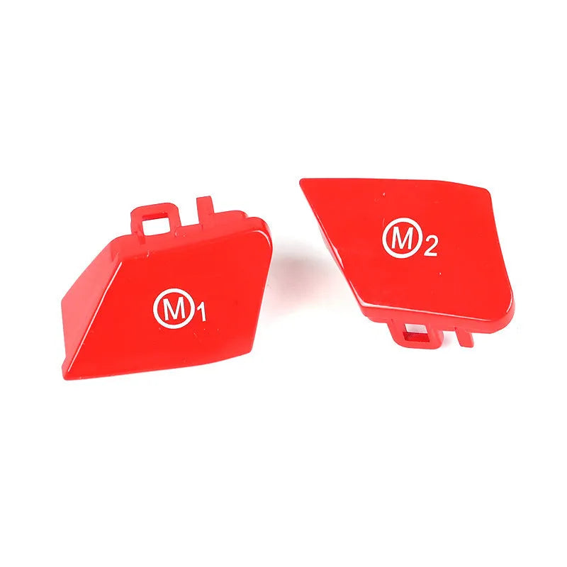 Pair of red and blue BMW M1 and M2 steering wheel mode buttons on a white background.