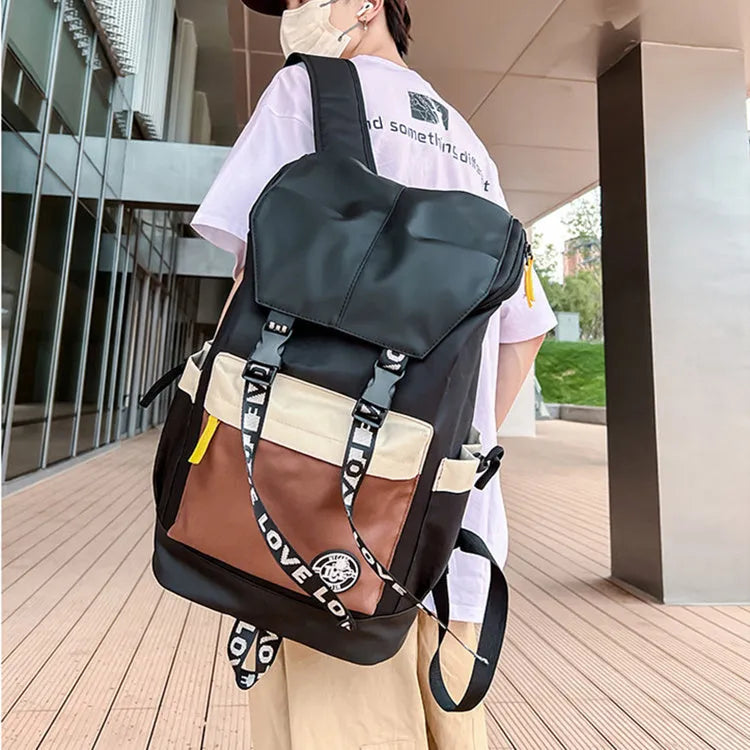 A mid-size black Oxford cloth backpack shown with handheld and two-shoulder carry options.