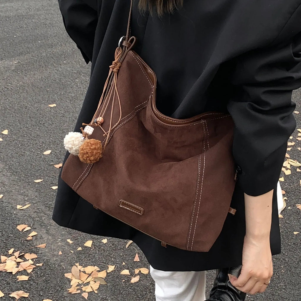 Large capacity coffee colour suede messenger bag with visible sewing line detail and single shoulder strap, shown on a plain background.