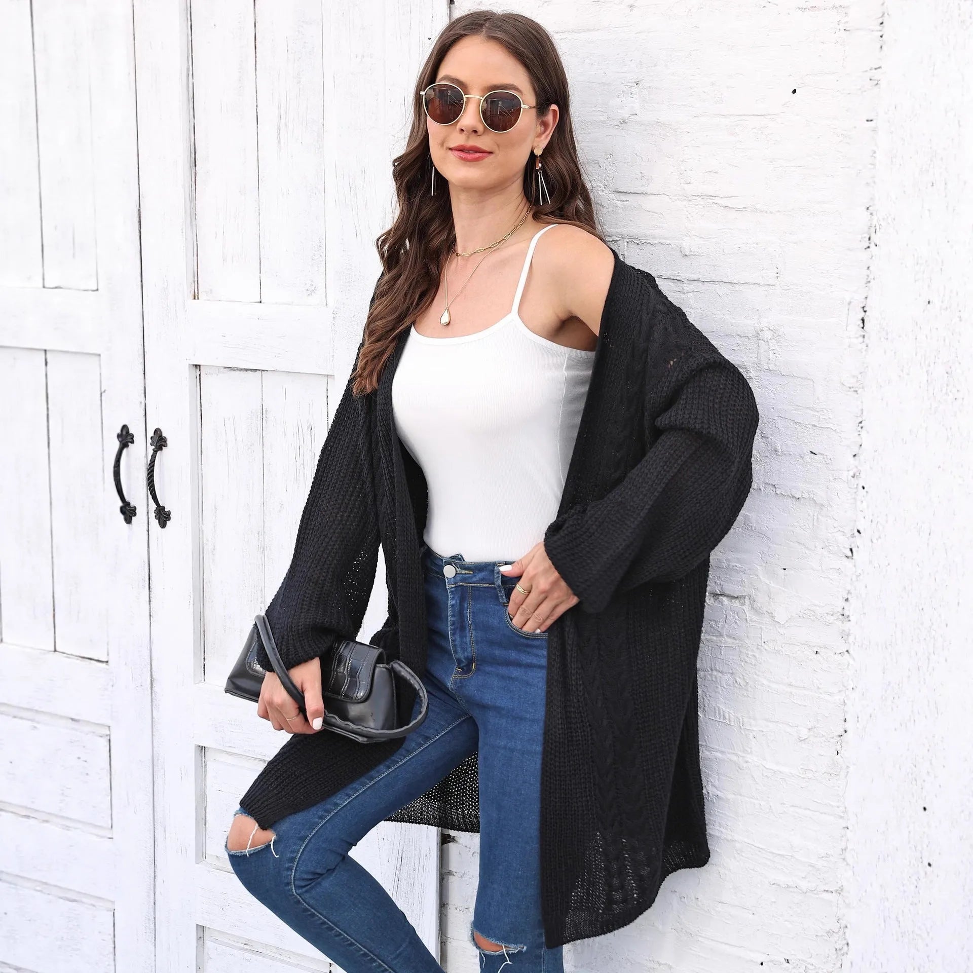 Women's loose fit acrylic sweater coat cardigan in a solid colour on a hanger.