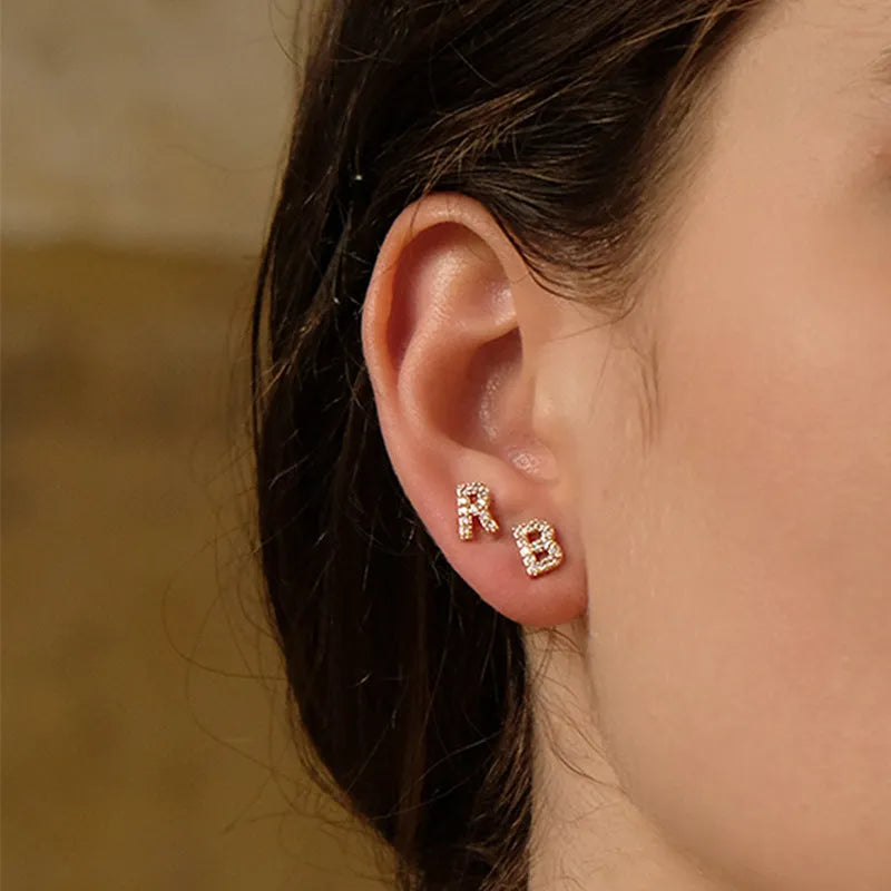 Gold plated alphabet letter earrings showing brass construction with zircon detail on English letters