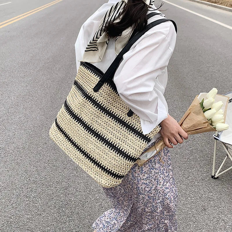 Large striped straw woven handbag with 64cm shoulder strap and polyester lining, shown in khaki or black