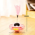 Pink rotating cat tumbler toy measuring 17 by 10 centimetres on a flat surface