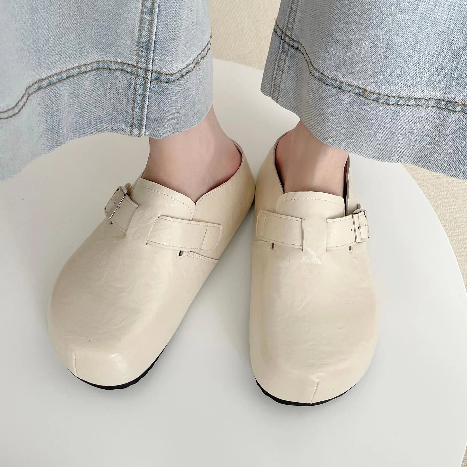 Flat buckle casual slippers with round toe and PU upper in beige colour on a clean surface
