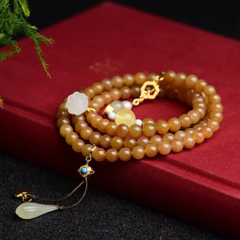 Women's jade bracelet with 6mm round beads showing clear water green pine pattern and leaf sequin accents