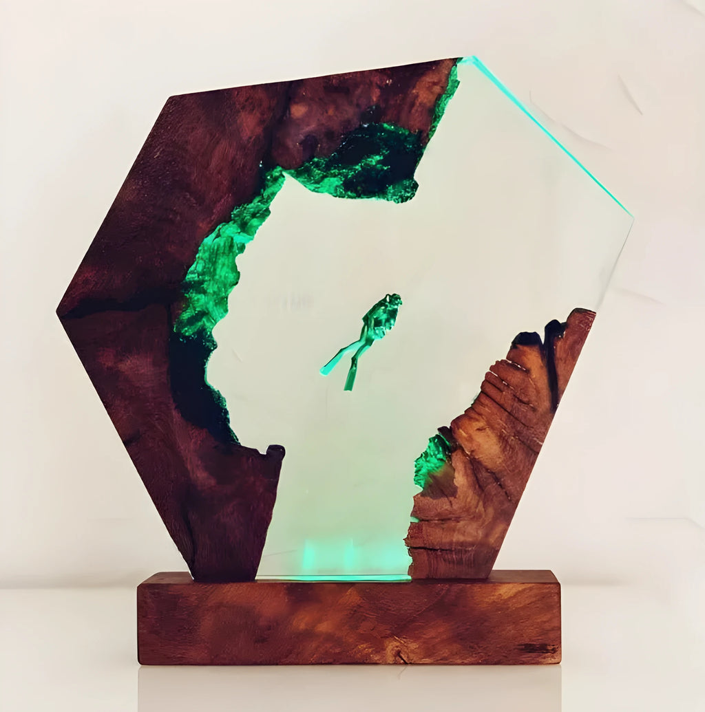 Small transparent resin luminous diver and humpback whale night light with USB plug on shelf