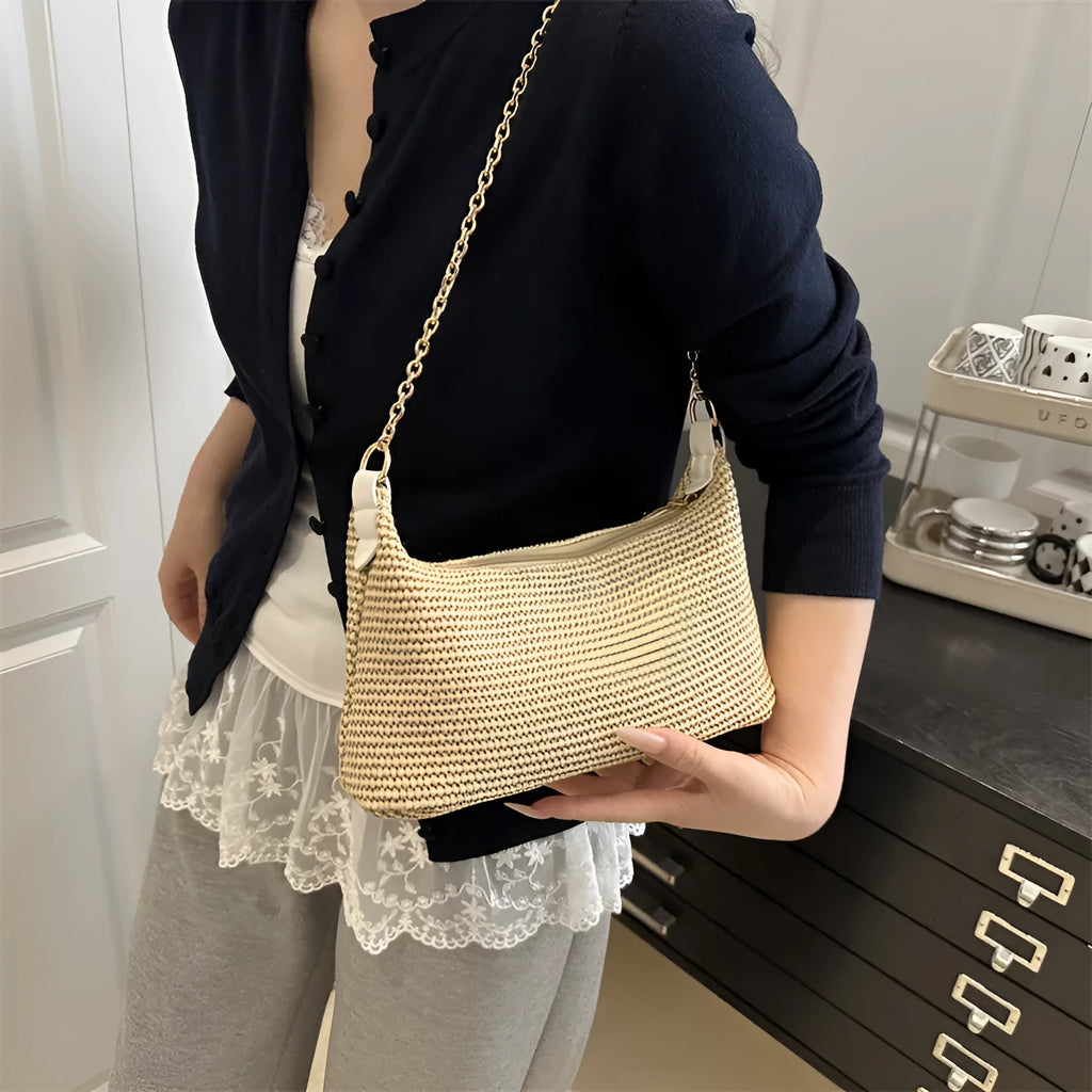 Khaki woven straw crossbody handbag with square shape and crossbody strap.