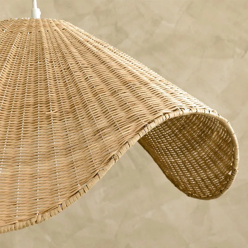 Handmade bamboo and straw rattan chandelier ceiling light with warm LED illumination in a rustic setting.