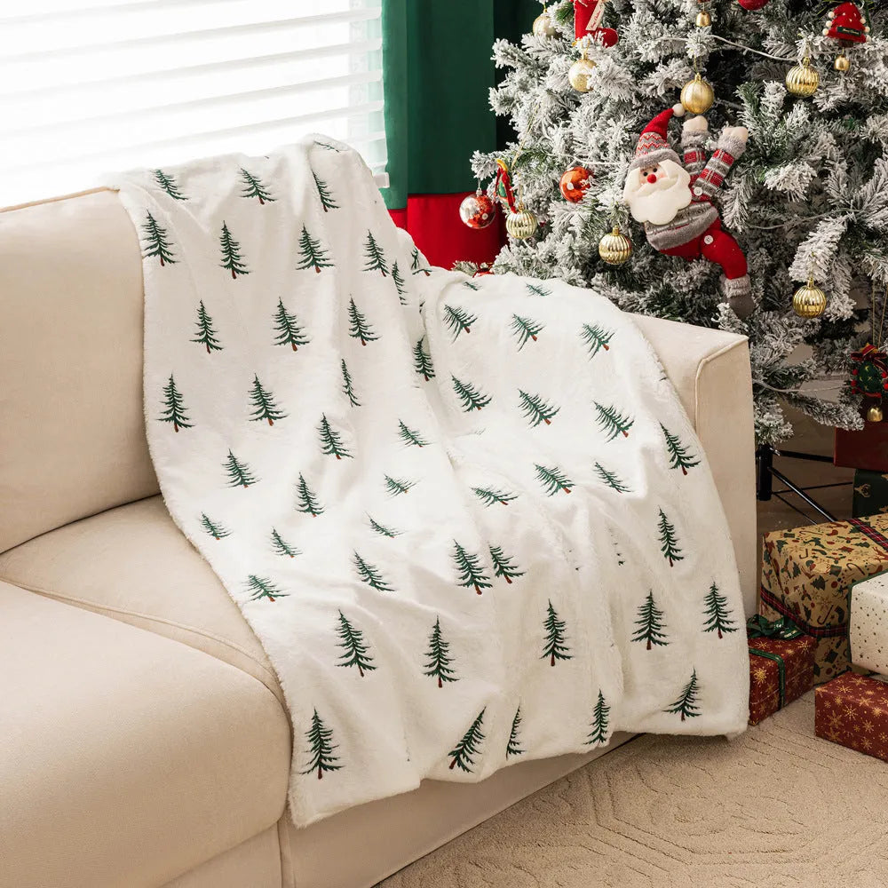 White polyester Christmas plush sofa blanket with embroidered Christmas tree design on a sofa