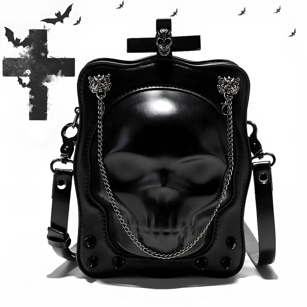 Black square crossbody bag with embossed skull design and metal chain strap against dark background