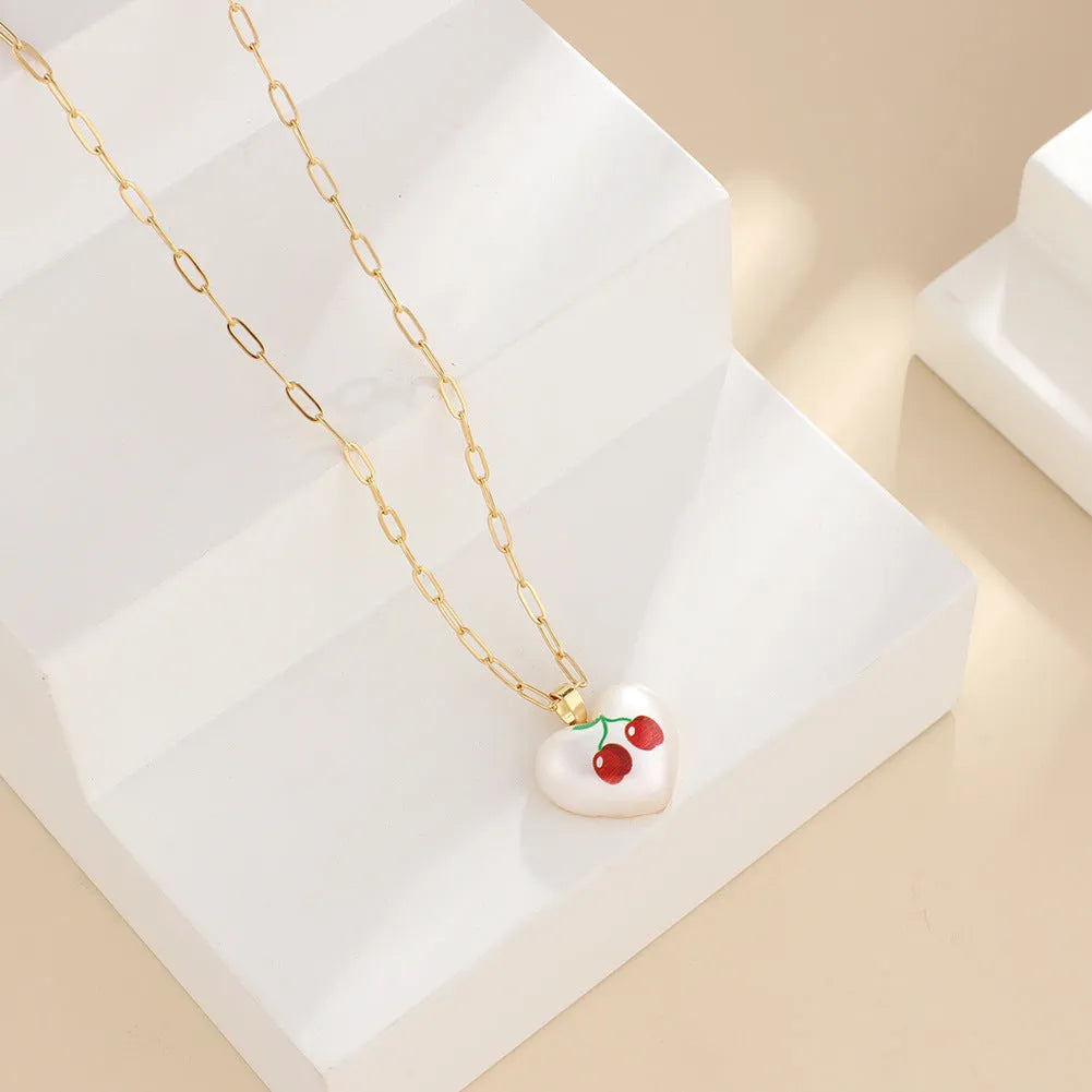 Geometric heart-shaped necklace with a detailed strawberry charm pendant on an adjustable chain.