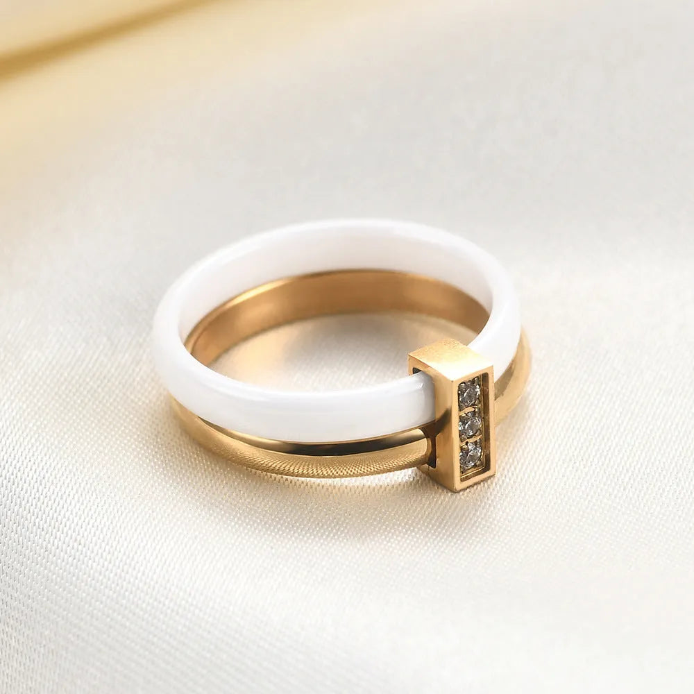 A Steel Black ceramic women's ring with glossy stitching and inlaid zirconium stones on a wooden surface.